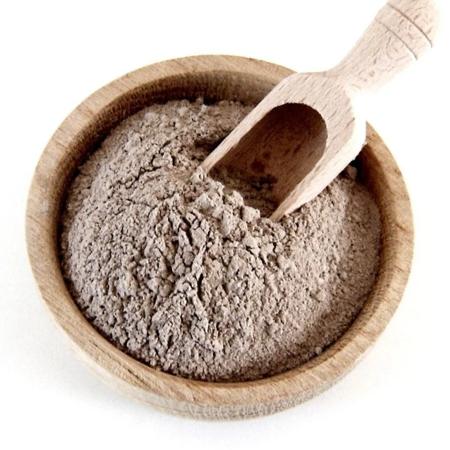 Argan press cake powder in a wooden bowl with a scoop