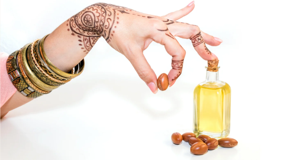 A hand pouring freshly pressed argan oil